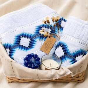 "Kit de presente de banho Bem-Estar Oceânico com toalhas azuis Karsten, velas artesanais e cesto de bambu."